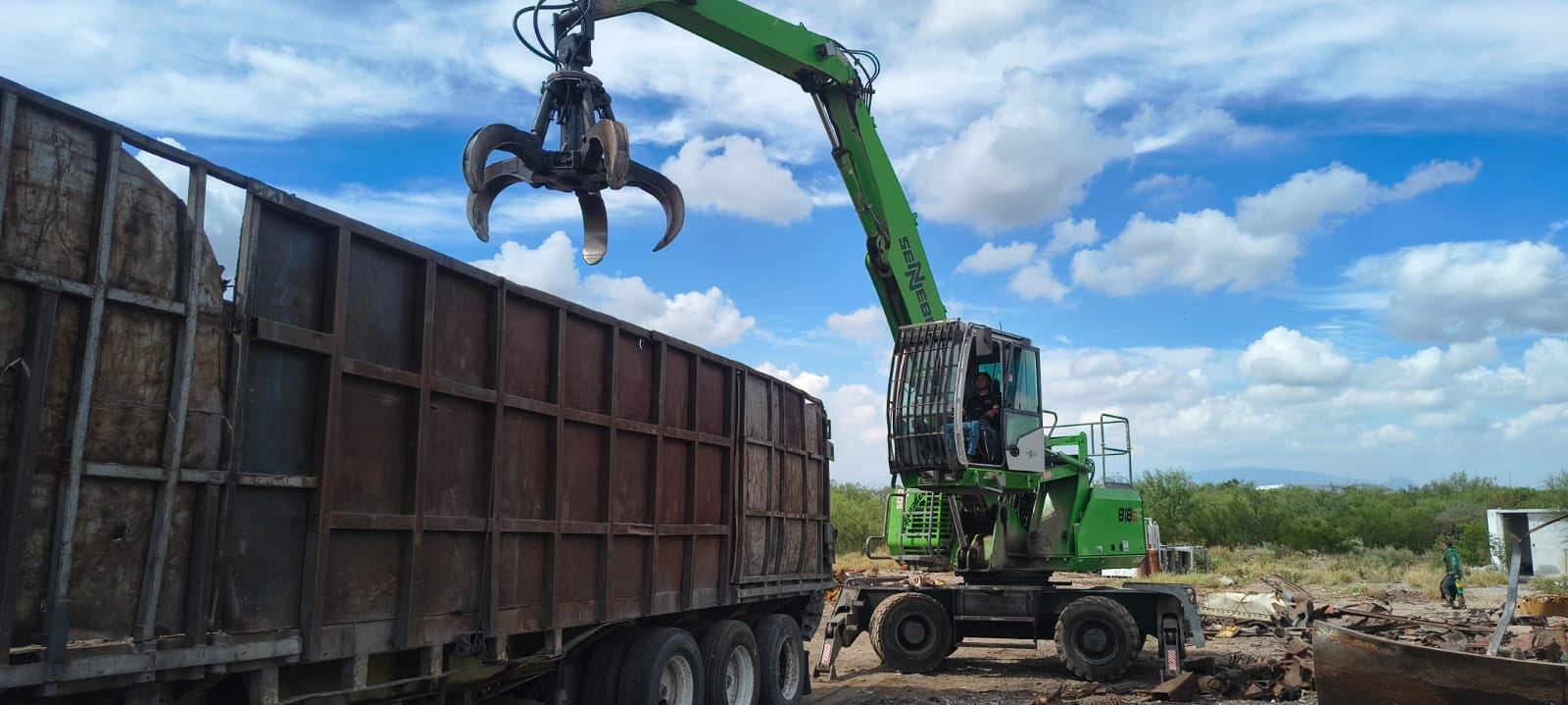 Grúa cargando chatarra en una caja